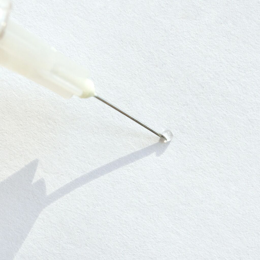close up of hypodermic needle on white background with shadow and transparent
